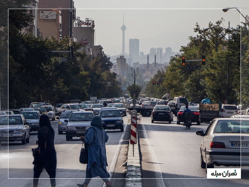 یکی از خیابان های تهرانپارس غربی در یک روز آفتابی با درختان و ساختمان‌های مسکونی